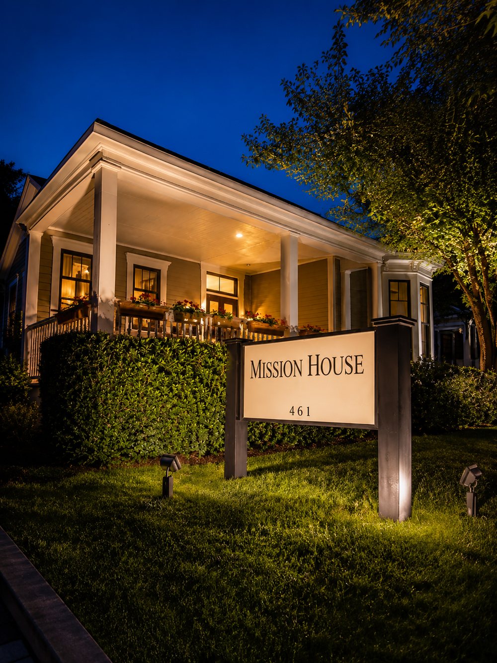 The Mission House at night with its sign lit